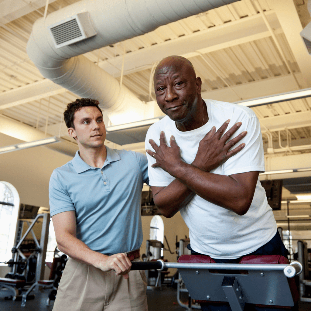 Pioneer Senior Physical Therapy A senior man practicing balance exercises with a Pioneer physical therapy specialist in a gym.