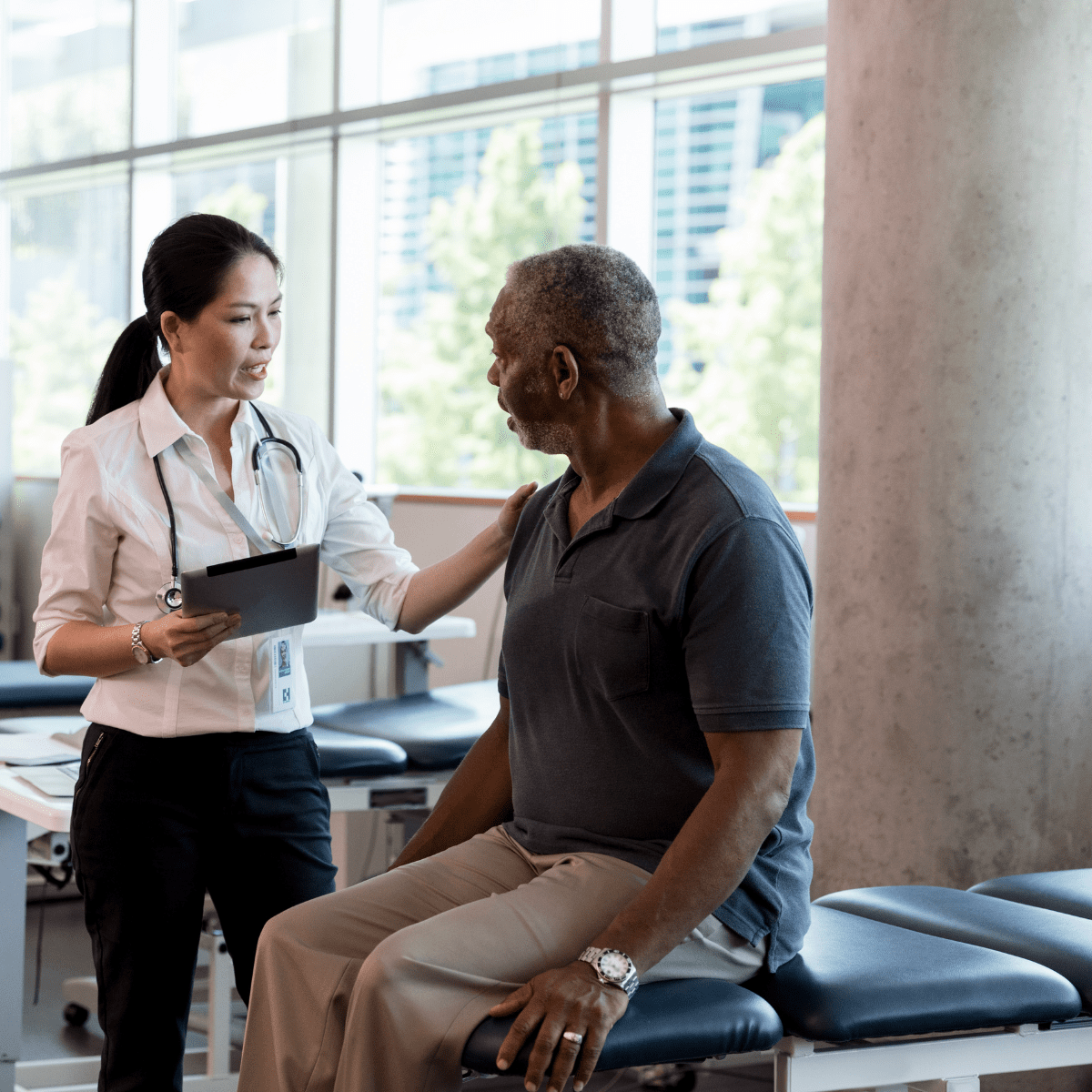 A female healthcare professional at Pioneer talking with a senior man during a consultation.