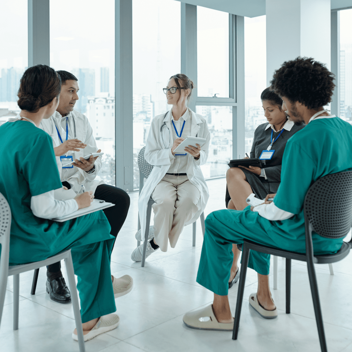 A diverse group of healthcare professionals and SLP students participating in a clinical round table discussion about patient care.