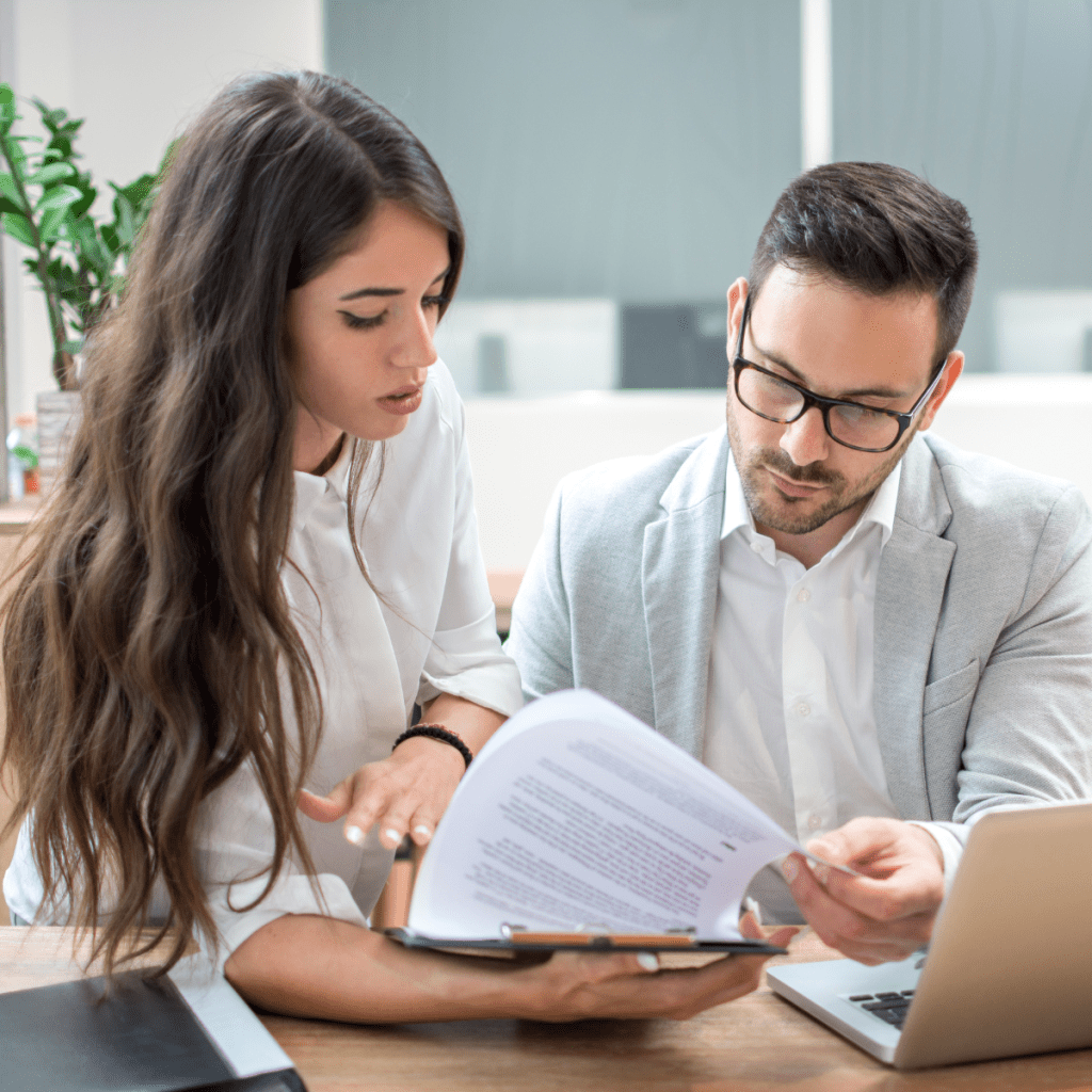 Two healthcare clinicians reviewing patient files and psychological assessments to develop a comprehensive, holistic treatment plan.