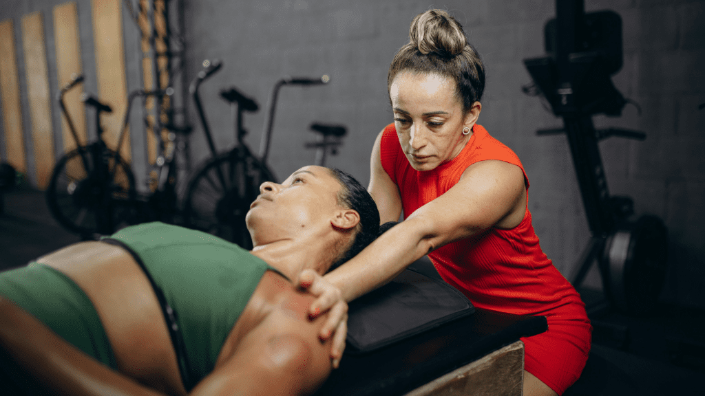 A physical therapist performing cupping therapy on an athlete’s shoulder in a gym setting to improve recovery and performance.