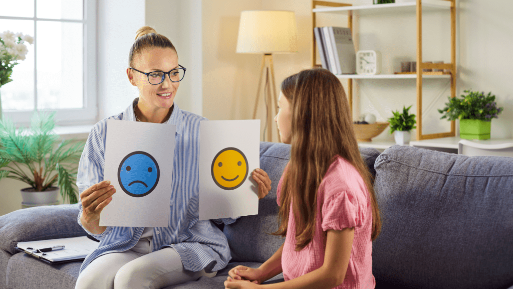 Therapy session with psychologist and child discussing emotion cards to help the girl name feelings and build communication. Mental health and emotional support concept. 