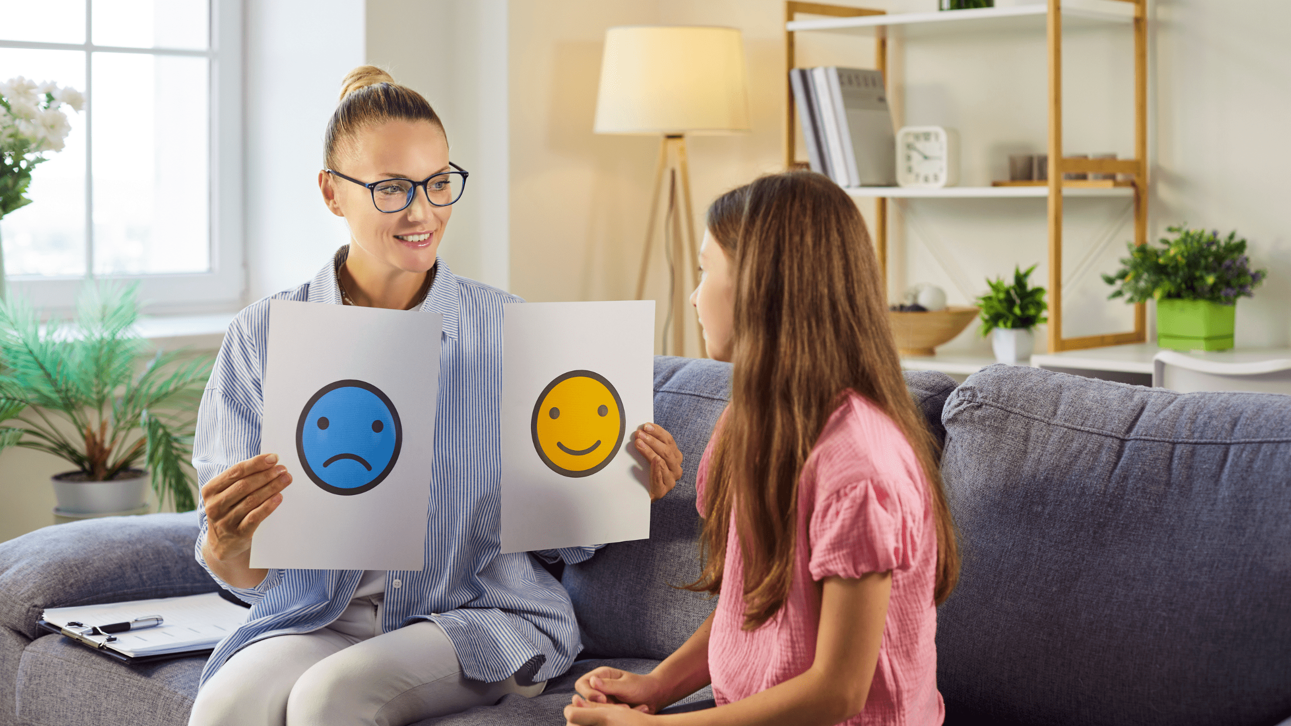 Therapy session with psychologist and child discussing emotion cards to help the girl name feelings and build communication. Mental health and emotional support concept.
