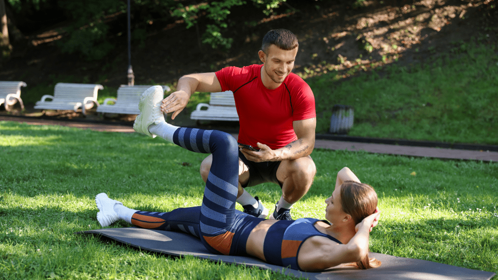 Young woman exercising with professional personal trainer outdoors